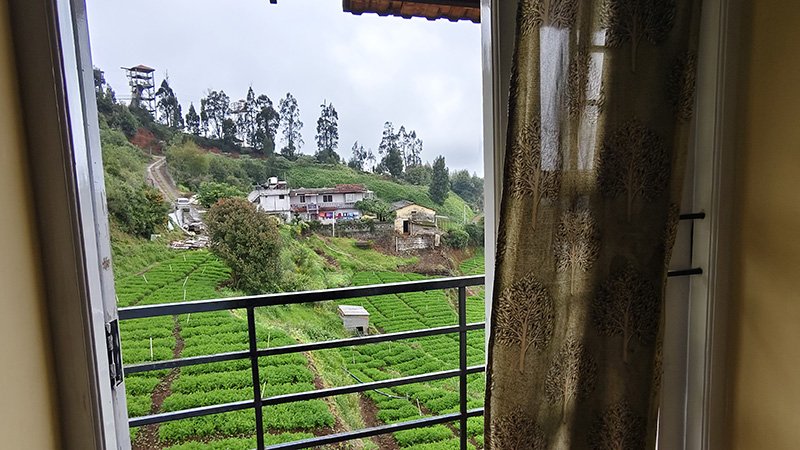Bedroom with scenic valley and tea field view