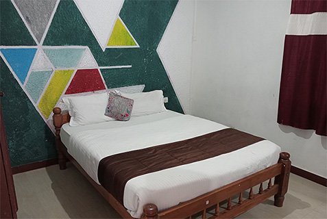 Hotel room with a bed and geometric mural