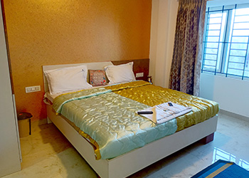 Spacious master bedroom with a window view at RJ Cottage, Ooty