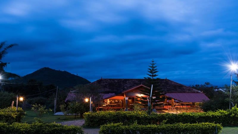 Mountain resort illuminated in the evening with landscaped gardens and hills behind