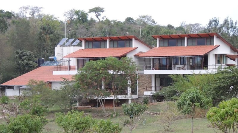 Hillside holiday homes with red tiled roofs surrounded by trees and natural greenery