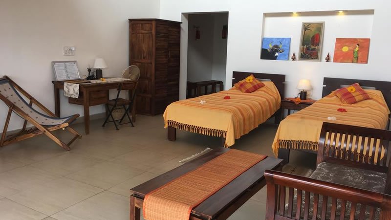 Twin bedroom with two single beds, wooden furniture, desk and seating area