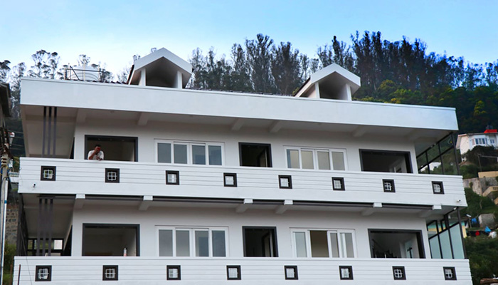 Modern three-story white cottage with balconies