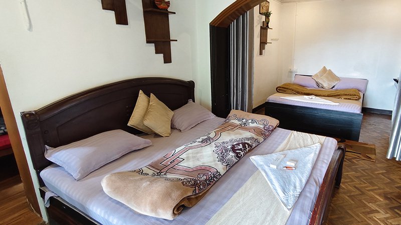 Family bedroom with multiple bed arrangement, wooden flooring and comfortable interior layout