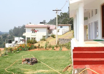 Lawn with fire pit, red steps, and hillside cottage at Green View