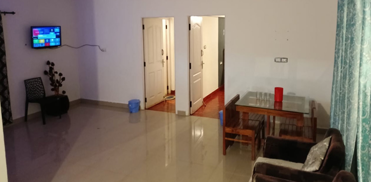 Spacious hallway featuring a TV and sofa, with doorways leading to bedrooms