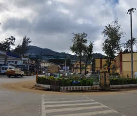 Charing Cross Ooty with the surrounding road, shops, and Nilgiri hills