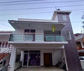 Cottage with glass balcony, tiled roof and covered entrance