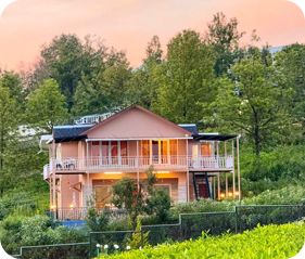 Cottage surrounded by lush greenery with a covered balcony and garden
