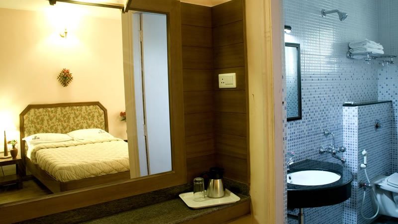 Double bedroom with attached bathroom, large mirror and tea making area