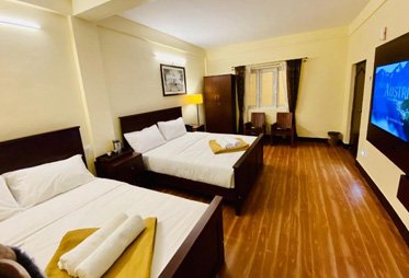 Family room with two double beds and wooden flooring