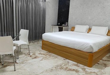 Modern hotel room with king-size bed and marble flooring