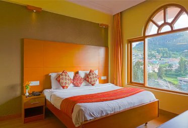 Hotel room with scenic valley view through large arched window