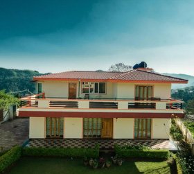 Spacious two-storey hotel with red roof and mountain views in Ooty