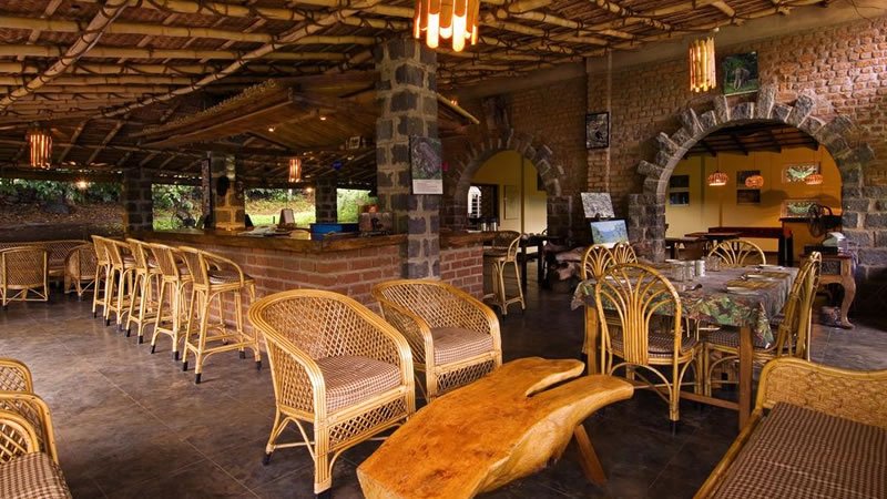 Rustic dining area with wicker chairs, wooden tables, brick arches and natural decor