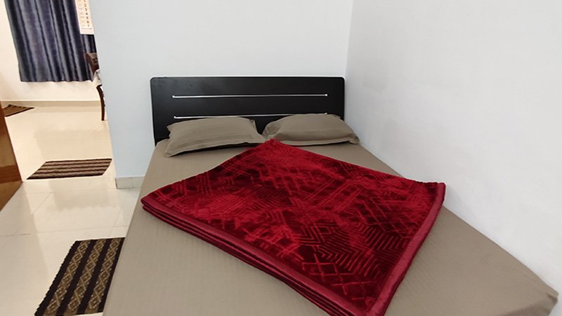 Bedroom with double bed and red blanket