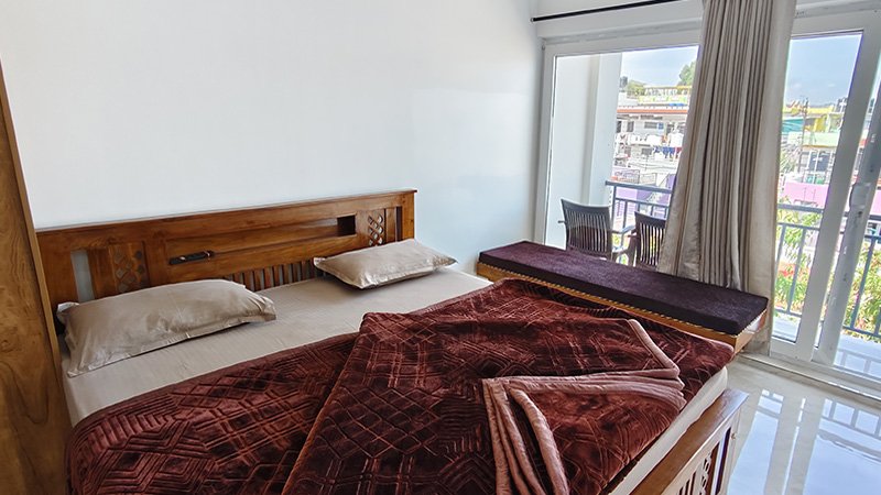 Bedroom with wooden bed and balcony window