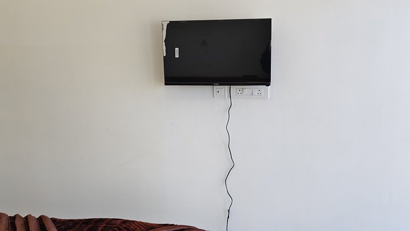 Wall mounted TV on white bedroom wall