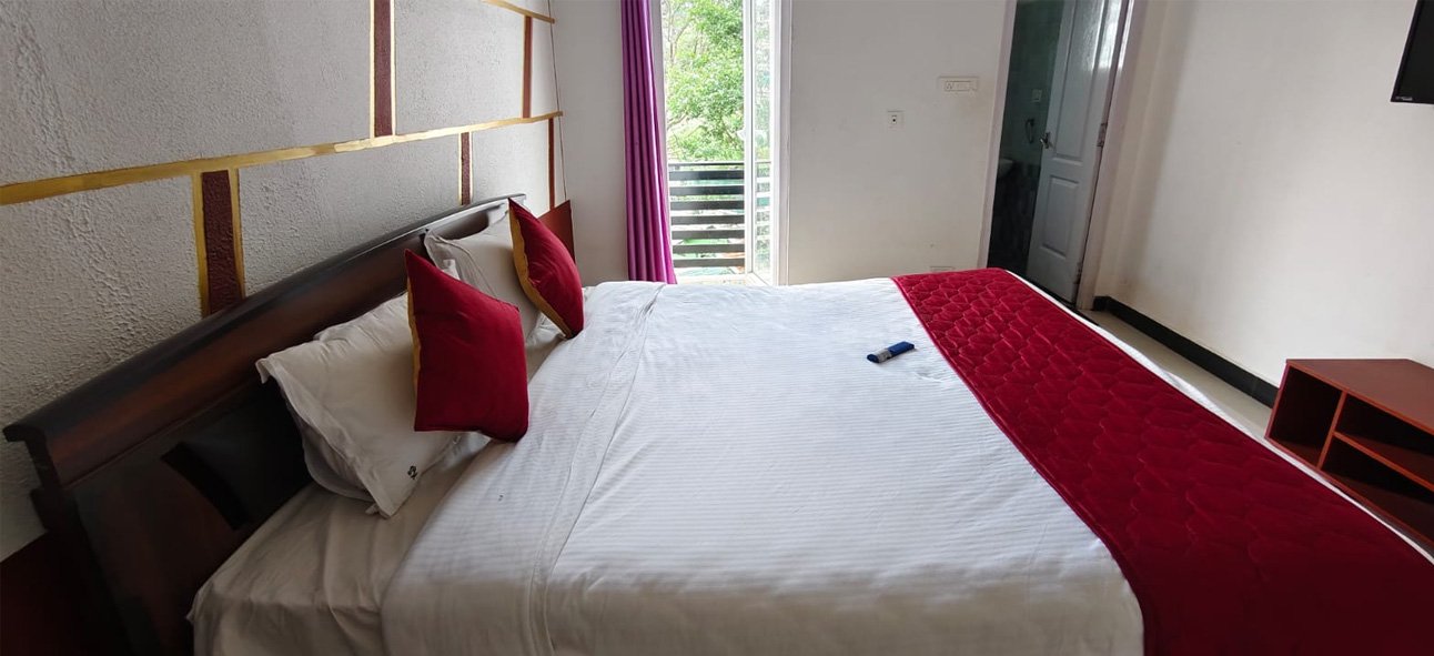 Bedroom with a balcony overlooking green surroundings