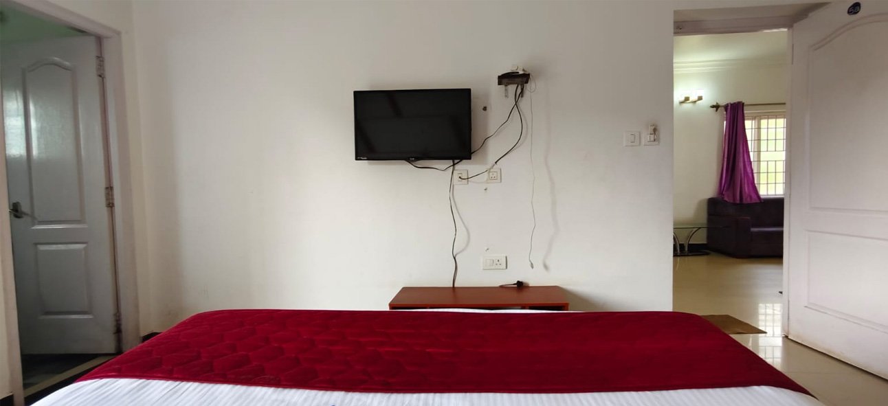 Bedroom with a wall-mounted television and double bed
