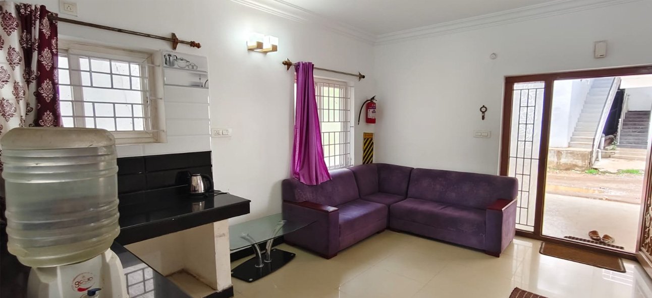 Living area with sofa, kitchenette and drinking water dispenser