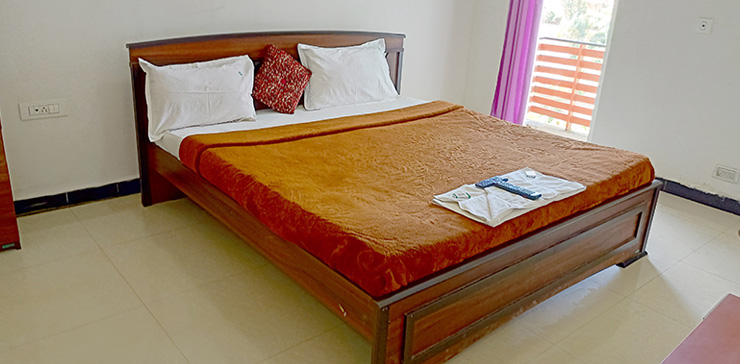 Bed with brown blanket and balcony