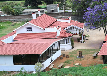 Charming white cottage exterior at Nithy's Cottages in Ooty