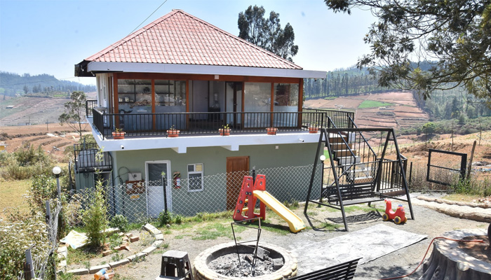 Ooty hillside cottage with balcony, play area, and bonfire pit, offering stunning valley views