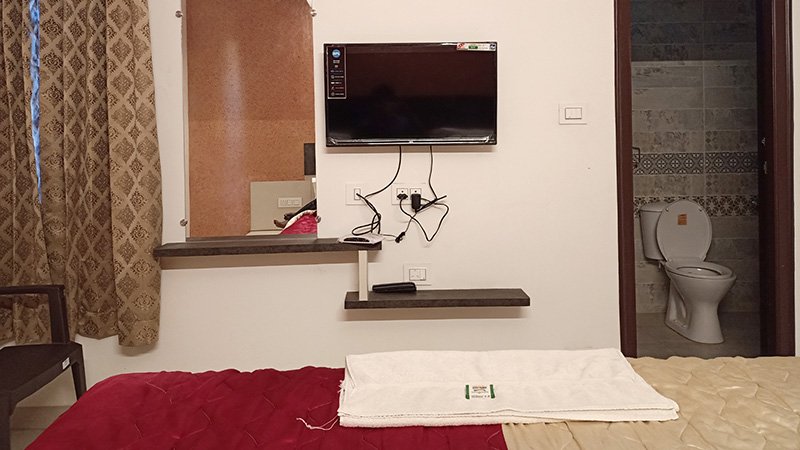 Bedroom with wall-mounted TV and bathroom entrance