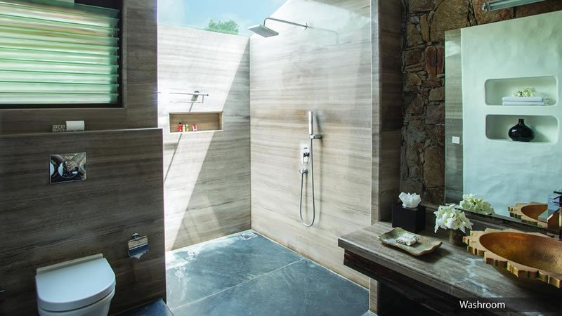 Modern bathroom with walk-in shower, stone wall, toilet and vanity area