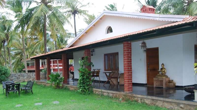 Spacious holiday home with covered veranda, garden seating and surrounding palm trees