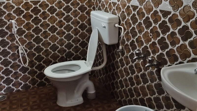 Bathroom with water heater, shower, western toilet and tiled walls
